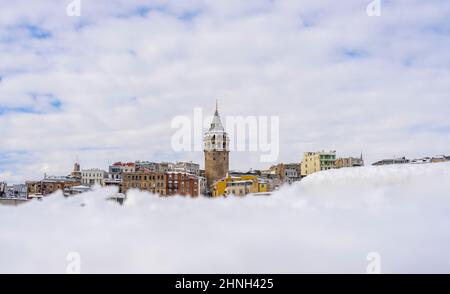 Wunderschöne Winteransicht des Galata Turms und farbenfrohe Häuser inmitten des Schnees in Istanbul, Türkei. Stockfoto