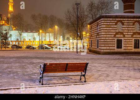 Nachtansicht eines mit Schnee bedeckten Moscheehufes im Winter. Beleuchtete Nachtansicht des Uskudar-Viertels in Istanbul, Türkei. Stockfoto