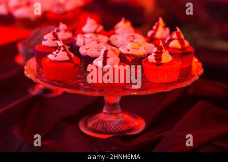 Leckere Kuchen auf Ständer auf schwarzem Hintergrund. Stockfoto