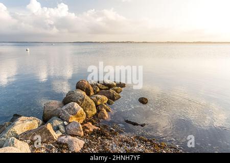 Felsen an einem Kiesstrand an der ruhigen Ostsee im ruhigen Morgenlicht Stockfoto