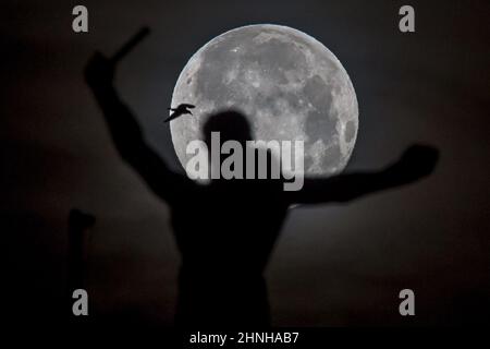 Barcelona, Spanien. 17th. Februar 2022. Barcelona, Spanien. Ein Vollmond, bekannt als der Wolf, steht hinter einem Denkmal in Barcelona, Katalonien. Foto: Marcin Nowak/Alamy Live News Stockfoto