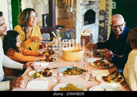 Glückliche lateinische Familie Spaß beim gemeinsamen Essen zu Hause - Fokus auf Großvater Gesicht Stockfoto
