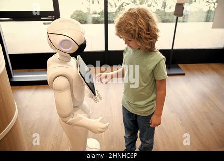 Roboter bieten Unterstützung für das Kind. Automatisierung. Künstliche Intelligenz interagieren mit Jungen Stockfoto