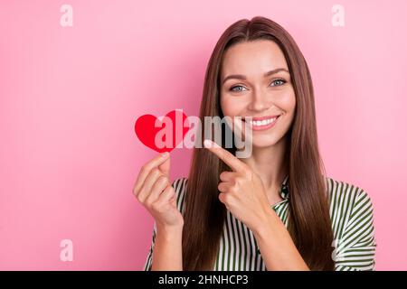 Foto von schönen tausendjährigen Brünette Dame Index Herz tragen gestreiftes Hemd isoliert auf rosa Hintergrund Stockfoto