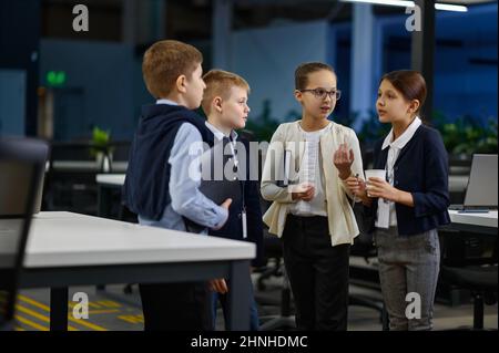 Das Business-Team der Kinder diskutiert die Arbeit im Büro Stockfoto