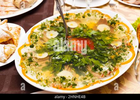 Aspik aus Fleisch, verziert mit Petersilie auf einem festlichen Tisch Stockfoto