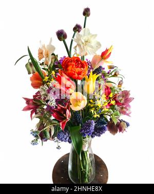 Die Kunst der Blumenarrangements. Bouquet von bunten Gartenblumen auf weißem Hintergrund isoliert. Die Komposition umfasst Tulpen, Narzissen, Allium, M. Stockfoto