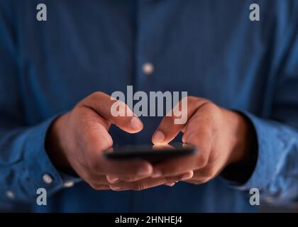 Nahaufnahme eines Mannes, der auf einem Smartphone tippt Stockfoto