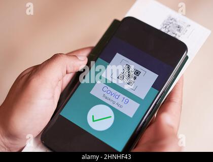 Covid19 Tracking-App, die von einem Mann auf Reisen gehalten wird Stockfoto