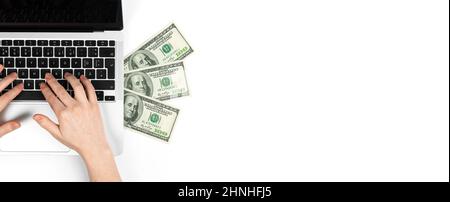 Freiberuflicher Mitarbeiter, der am Laptop arbeitet und Geld verdient, US-Dollar auf weißem Tisch, Draufsicht Stockfoto