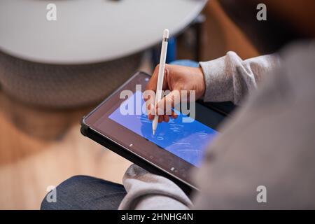 Eine Nahaufnahme der Hände eines Mannes mit einem Stift, um auf einem Tablet zu zeichnen Stockfoto