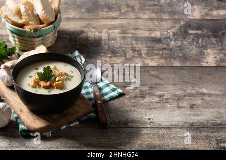 Knoblauchsuppe garniert mit Croutons in Schüssel auf Holztisch Stockfoto