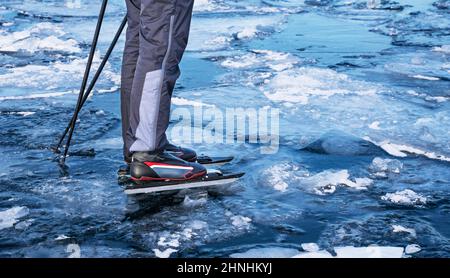 Spezielle lange Schlittschuhe für lange Strecken. Befestigung für Skischuhe.Touristen Schlittschuh auf dem gefrorenen Baikalsee. Stockfoto