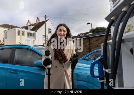 Dame mittleren Alters, die die Fahrzeugladestation „GeniePoint EV Charging“ in Hampshire, England, Großbritannien, verwendet Stockfoto