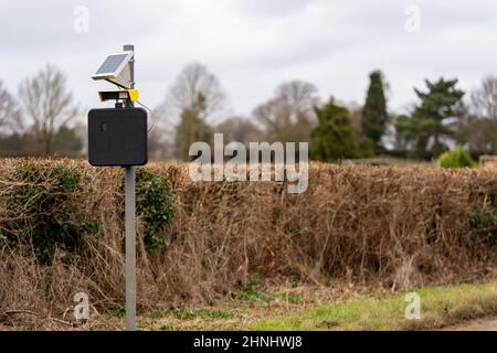 Solarbetriebene Geschwindigkeitsfalle, die eine Kennzeichenerkennung eingebaut hat, um Menschen zu fangen und zu verfolgen, die durch ein Dorf auf dem Land Rasen Stockfoto