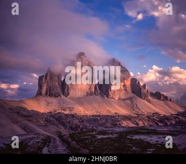 Das Bild zeigt die berühmten drei Türme, die auf Deutsch drei Zinnen heißen, aber auf Italienisch poetischer als die drei Zinnen di Laverado in der Region Sexten-Sexten im Osten der italienischen Dolomiten benannt sind. Während des Ersten Weltkriegs, bekannt als der Weiße Krieg, stellten die Gipfel eine natürliche Barriere zwischen den Italienern und den streikenden Österreichern dar, wobei die Front durch die Gipfel lief. Stockfoto