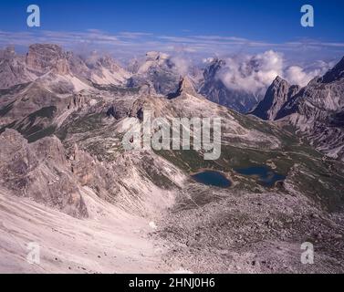 Das Bild stammt vom geschützten Klettersteig auf dem Paternkofel mit Blick auf die Berghütte Locatelli drei Zinnen und die Spitze der Toblinger Knoten Spitze in der Nähe der berühmten drei Türme, Auf Deutsch bekannt als drei Zinnen, aber poetischer auf Italienisch als die drei Zinnen di Laverado in der Region Sexten-Sexten im Osten der italienischen Dolomiten benannt. Während des Ersten Weltkriegs installierte die österreichische Armee auf dem kleinen Gipfel ein Kanonenfeldgewehr, um die Schale der Italiener etwas mehr als einen Kilometer entfernt zu erhalten. Stockfoto