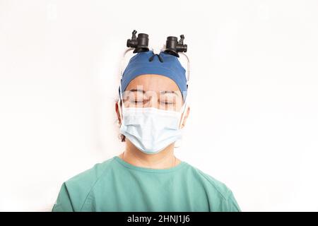 Sterile weibliche Krankenschwester oder Chirurg, die einen sterilen grünen Anzug oder ein Kleid trägt, warten isoliert auf dem Operationssaal. Stockfoto