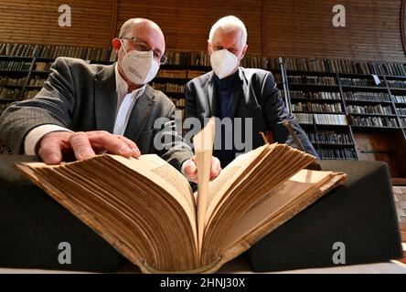 Erfurt, Deutschland. 17th. Februar 2022. Michael Ludscheidt (l.), Leiter der Evangelischen Bibliothek des Augustinerklosters, und Andreas Lindner, Kirchenhistoriker der Universität Erfurt, werfen einen Blick auf eine restaurierte Anthologie von 41 Drucken Martin Luthers. Die Schriften stammen von 1518 bis 1523, die Restaurierung kostete rund 4200 Euro. Die Anthologie ist nun wieder für die Lutherforschung zugänglich. Quelle: Martin Schutt/dpa-Zentralbild/dpa/Alamy Live News Stockfoto