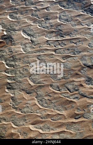 Wellenförmige Wellenmarkierungen mit Sand auf Stein am Strand, Textur, Hintergrund, Normandie, Frankreich Stockfoto