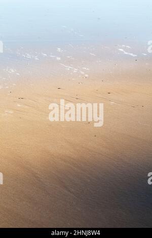 Spiel von Licht und Schatten morgens am Strand, abstrakte Meeresstimmung Stockfoto