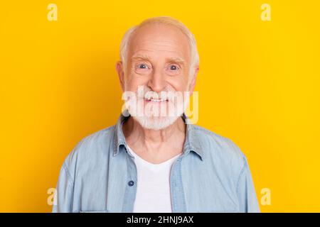 Portrait von attraktiven Inhalt fröhlich grauhaarigen Mann in Denim-Shirt isoliert über lebendige gelbe Farbe Hintergrund Stockfoto
