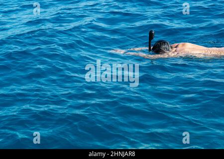 Schnorchelmann in Vollmaske, Sommerurlaubsaktivitäten, Schwimmen im warmen tropischen Meer Stockfoto