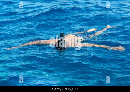 Schnorchelmann in Vollmaske, Sommerurlaubsaktivitäten, Schwimmen im warmen tropischen Meer Stockfoto