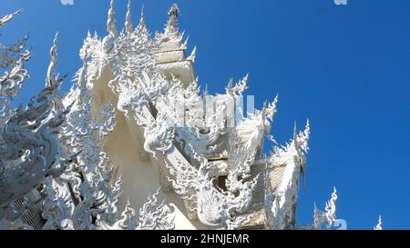 Schönes Dach mit einzigartigem Design auf blauem Himmel Hintergrund in White Temple Stockfoto