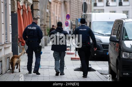 München, Deutschland. 17th. Februar 2022. Polizeibeamte gehen mit einem Hund in der Nähe des Hotels 'Bayerischer Hof' mit. Die Münchner Sicherheitskonferenz findet vom 18. Bis 20.02.2022. Im Hotel statt. Quelle: Sven Hoppe/dpa/Alamy Live News Stockfoto
