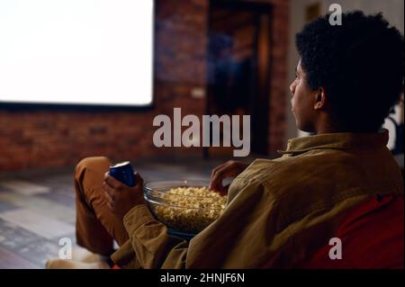 Der Mann genießt es, Filme mit einem Videoprojektor zu sehen Stockfoto