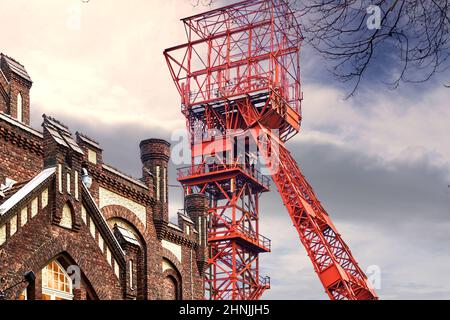 Essen, 9. Februar 2022: Roter, gewundener Turm der ehemaligen Kolonie Bonifacius hinter der Hotelfassade in einem umgebauten Zeche-Gebäude Stockfoto