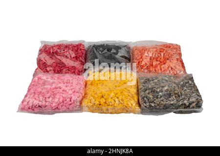 Bunte Kieselsteine in Plastiktüten für Dekorationsarbeiten im Handwerksbetrieb. Gepackte farbige Kieselsteine. Landschaftsdesign. Stockfoto