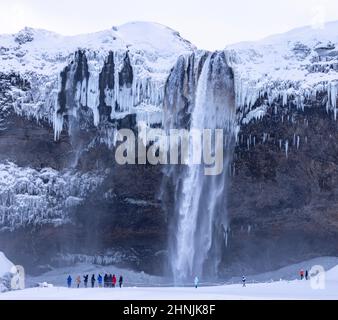 Touristen und Wasserfall in Seljalandsfoss, Vatnajokull National Park, Südosten Islands Stockfoto