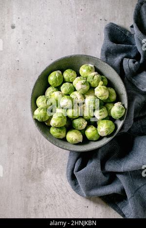 Haufen von geschälten rohen Bio-rosenkohl Mini-Kohl in Keramikschale auf hellgrauem Hintergrund. Gemüse gesund essen. Flach liegend, Platz Stockfoto