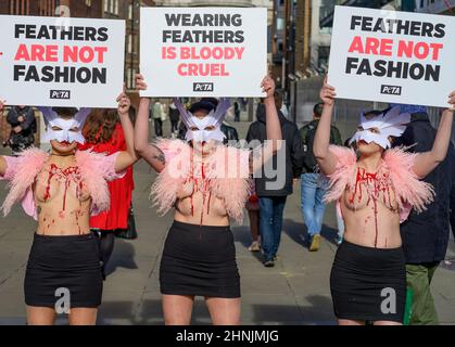 Millennium Bridge, London, Großbritannien. 17. Februar 2022. Um gegen den Einsatz von Federn bei der London Fashion Week zu protestieren, macht eine Schar von PETA-Anhängern am Donnerstag, dem 17th. Februar, die Millennium Bridge zu ihrem Laufsteg. Mit Vogelmasken und freigelegten „blutigen und gerupften“ Truhen heben sie die Notlage von Vögeln hervor, deren Federn für Modebekleidung und Accessoires herausgerissen werden. „Gefieder gehört sanften Vögeln, und die Menschen haben kein Recht, es ihnen von der Handvoll zu reißen“, sagt PETA-Direktorin Elisa Allen. „PETA fordert alle auf, mit fabelhaften veganen Textilien ein modisches Statement auf die freundliche Art und Weise zu machen.“ Kredit: Malcolm Park/A Stockfoto