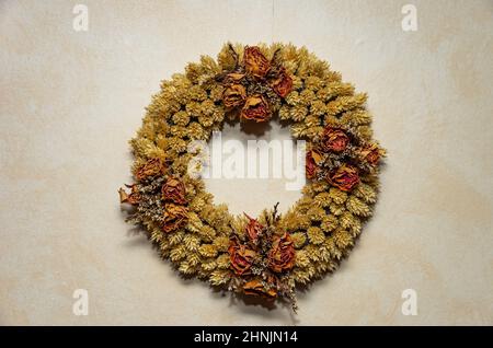 Ein Kranz aus getrockneten Blumen an der Wand. Stockfoto