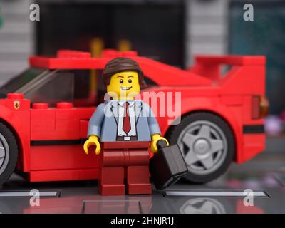 Tambow, Russische Föderation - 13. Februar 2022 Ein Lego Geschäftsmann Minifigur, der vor seinem Lego Ferrari F40 Auto steht. Stockfoto