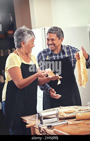 Noch besser als die Profis. Aufnahme eines reifen Paares, das zu Hause zusammen kocht. Stockfoto