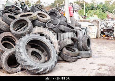 Stadtdumpen mit alten Reifen und Reifen zum Recycling. Recycling der Altgummireifen. Entsorgung abgenutzter Räder zum Recycling. Stockfoto