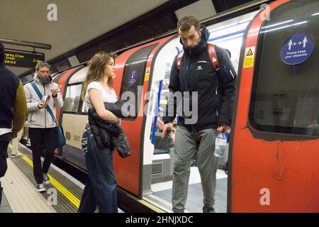 London, Großbritannien, 16. Februar 2022: An der U-Bahnstation Clapham Common tragen nicht alle Passagiere Gesichtsmasken, obwohl der Transport nach London sie als Beförderungszustand behält. Seit England zu den „Plan A covid“-Regeln zurückkehrte, gab es höhere Stufen von Menschen, die das TfL-Mandat für Gesichtsmaske ignorierten. Eine mögliche Beendigung aller covid Beschränkungen wird am Montag, den 21. Februar, im Parlament diskutiert. Anna Watson/Alamy Live News Stockfoto