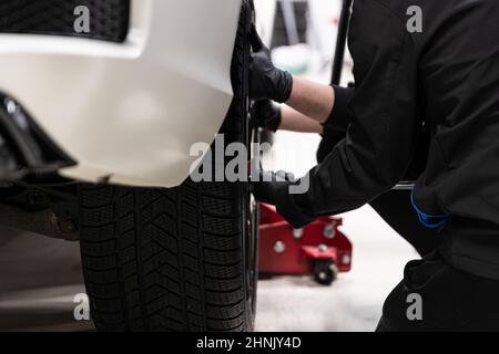 Mann Auto-Service-Arbeiter wechseln Rad im Auto. Stockfoto