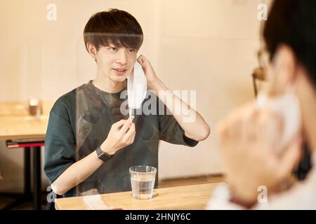 Zwei Japanische Männer, Die Ihre Masken Abheben Stockfoto