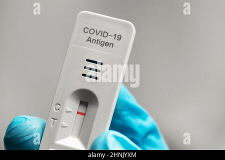 Ein negativer Covid-19-Antigen-Schnelltest in der Hand mit einem medizinischen Handschuh Stockfoto