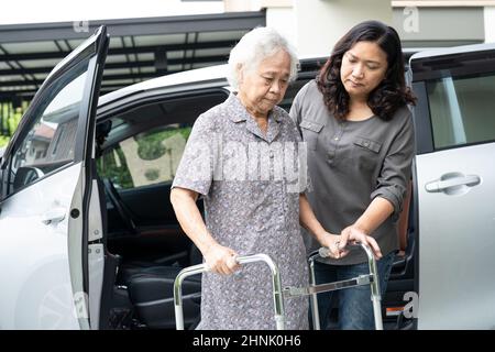 Hilfe und Unterstützung asiatische ältere oder ältere alte Dame Frau Patientin gehen mit Wanderer Vorbereitung zu ihrem Auto, gesund starke medizinische Konzept. Stockfoto