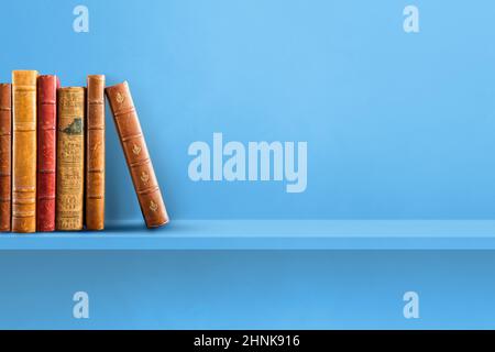 Reihe alter Bücher auf blauem Regal. Horizontaler Hintergrund Stockfoto