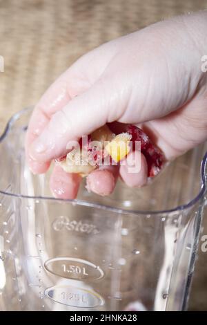 Eingefrorene Früchte in einen Mixer geben Stockfoto