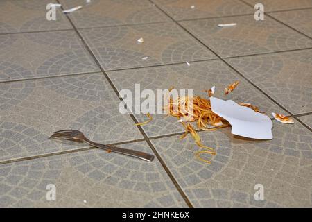 Abgefallener Teller mit Pasta auf dem Küchenboden Stockfoto