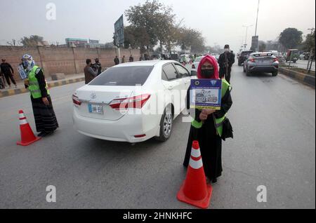 Die Teilnehmer der Freiwilligen-Organisation für den Straßenverkehr halten am Donnerstag, dem 17. Februar 2022, in Peshawar Informationsbroschüre und Horten über die Verkehrssicherheit während der Kampagne für Verkehrsgesetze und Straßenverkehrssicherheit ab. Stockfoto