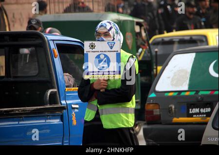 Die Teilnehmer der Freiwilligen-Organisation für den Straßenverkehr halten am Donnerstag, dem 17. Februar 2022, in Peshawar Informationsbroschüre und Horten über die Verkehrssicherheit während der Kampagne für Verkehrsgesetze und Straßenverkehrssicherheit ab. Stockfoto